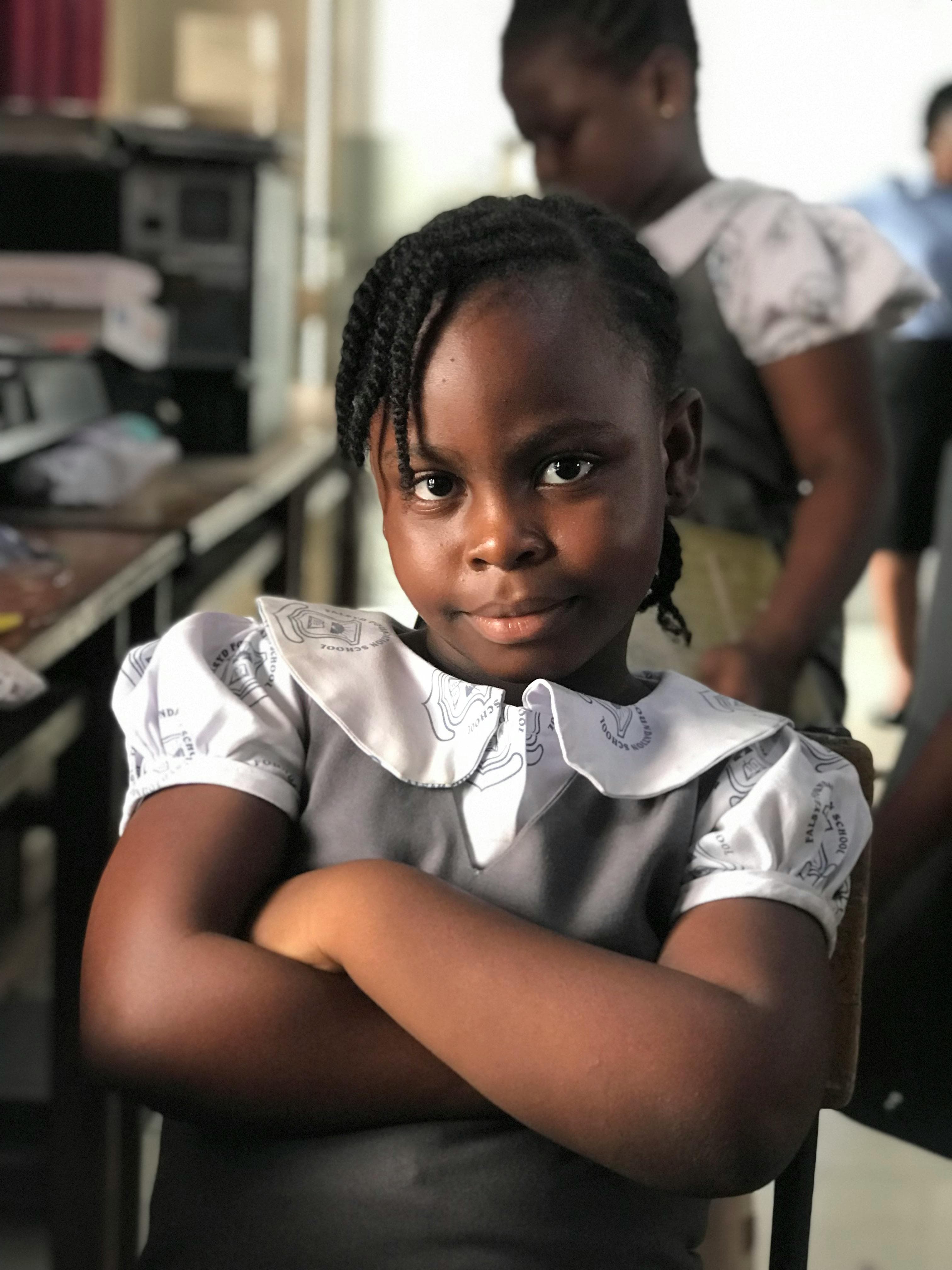 A Ghanaian schoolgirl smiling in her classroom