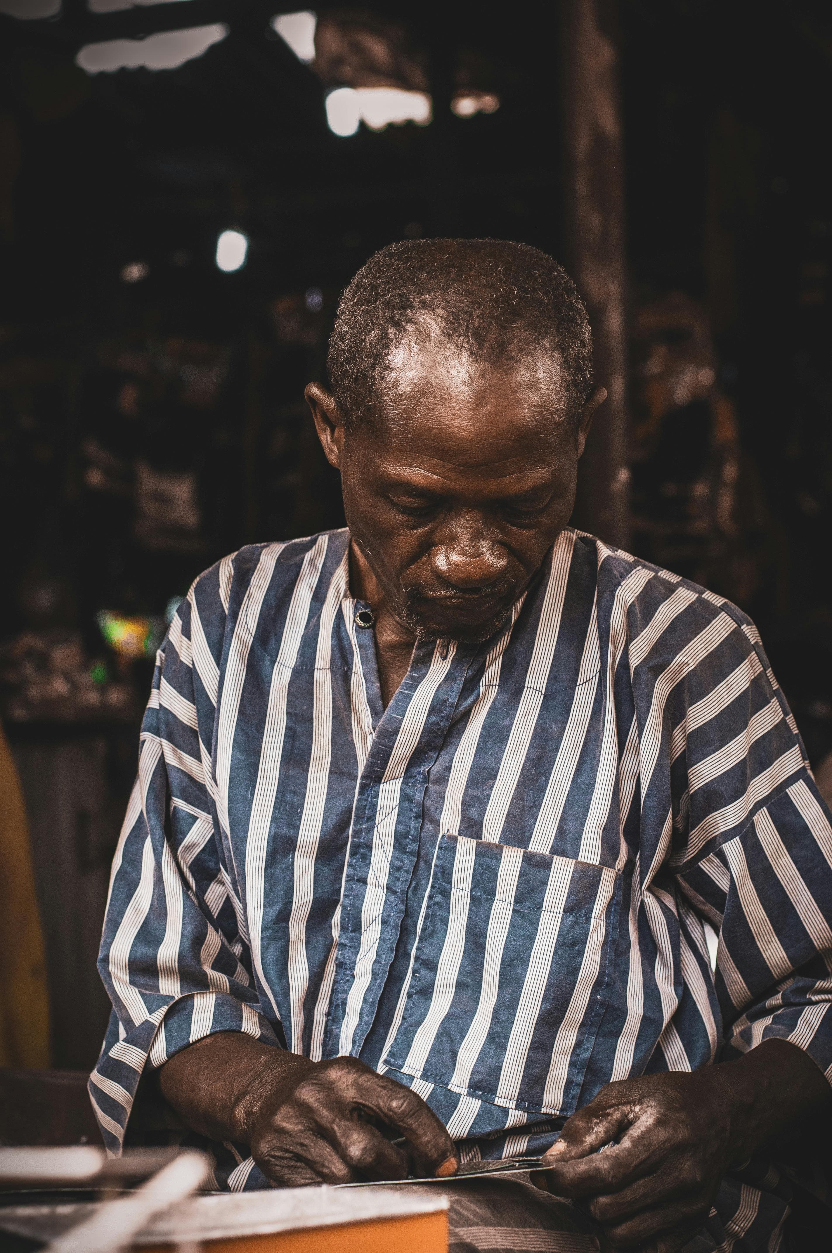 A Ghanaian craftsman measuring a board in his workshop